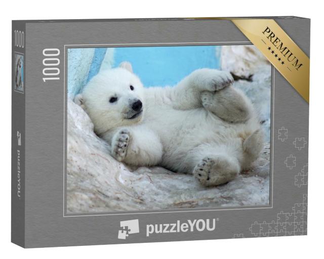 Puzzle 1000 Teile „Ein Eisbärenjunges liegt auf dem Rücken im Schnee“