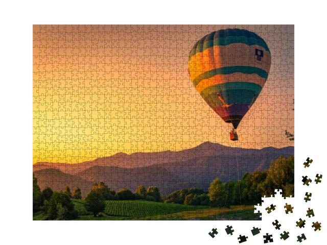Puzzle 1000 Teile „Heißluftballon in wunderschöner Landschaft bei Sonnenuntergang“