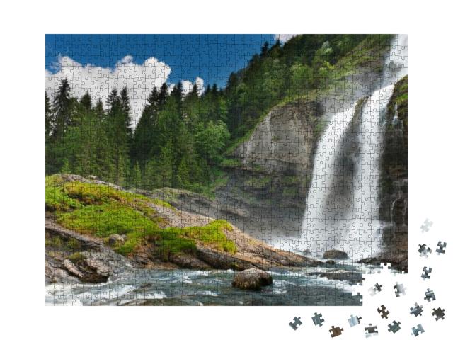 Puzzle 1000 Teile „Alpiner Wasserfall im Bergwald unter blauem Himmel“