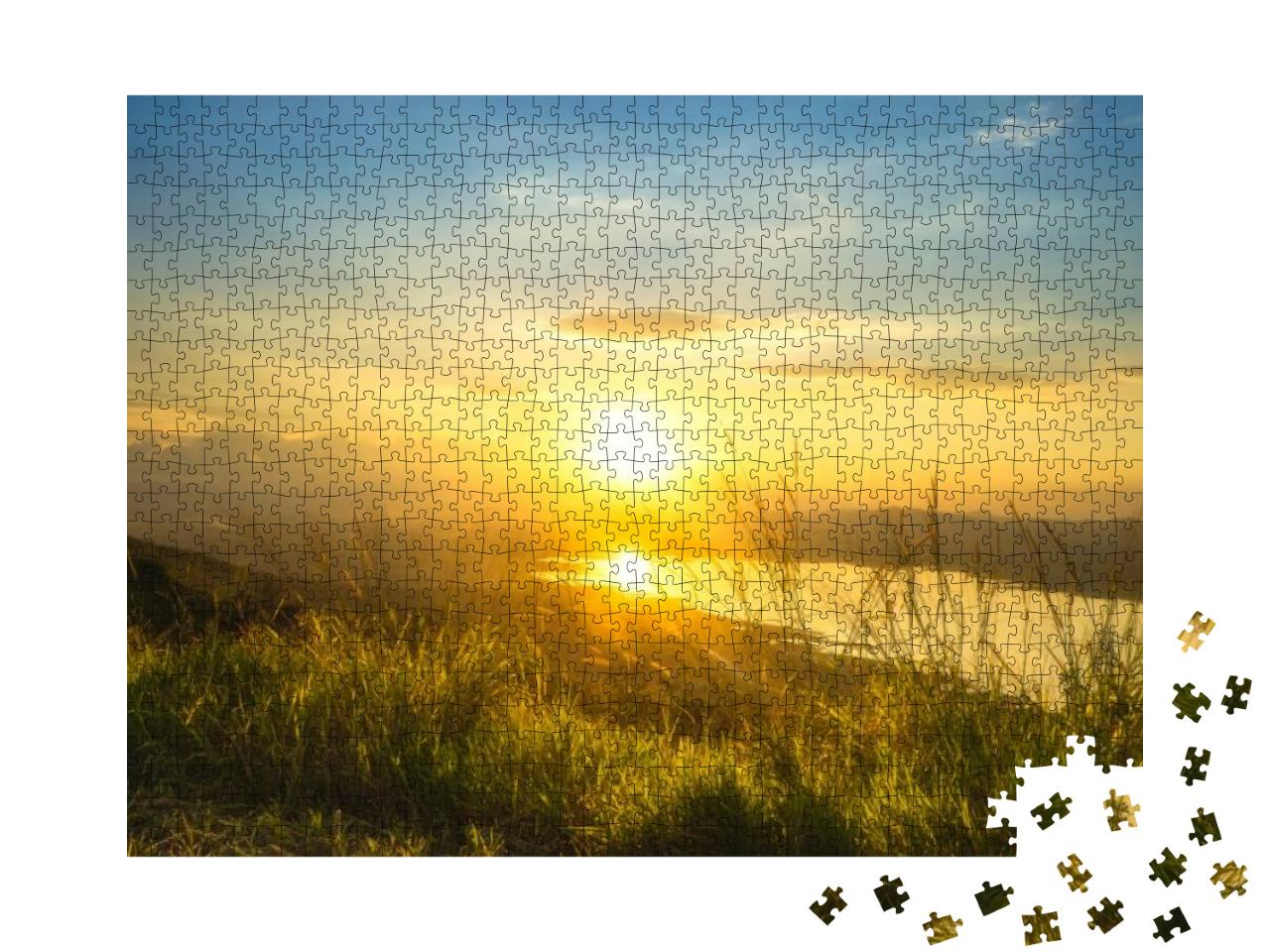 Puzzle 1000 Teile „Sonnenaufgang über einem See und grünen Hügeln“