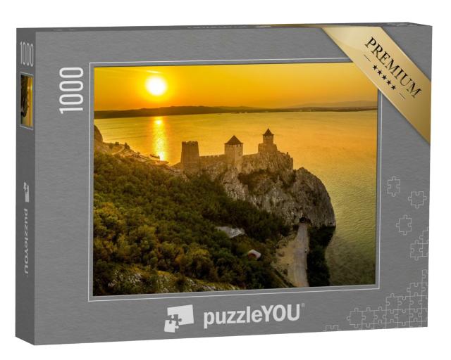 Puzzle 1000 Teile „Silhouette der Burg Golubac bei Sonnenuntergang in Serbien entlang der Donau“