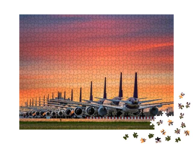 Puzzle 1000 Teile „Geparkte Flugzeugflotte am abendlichen Flughafen“